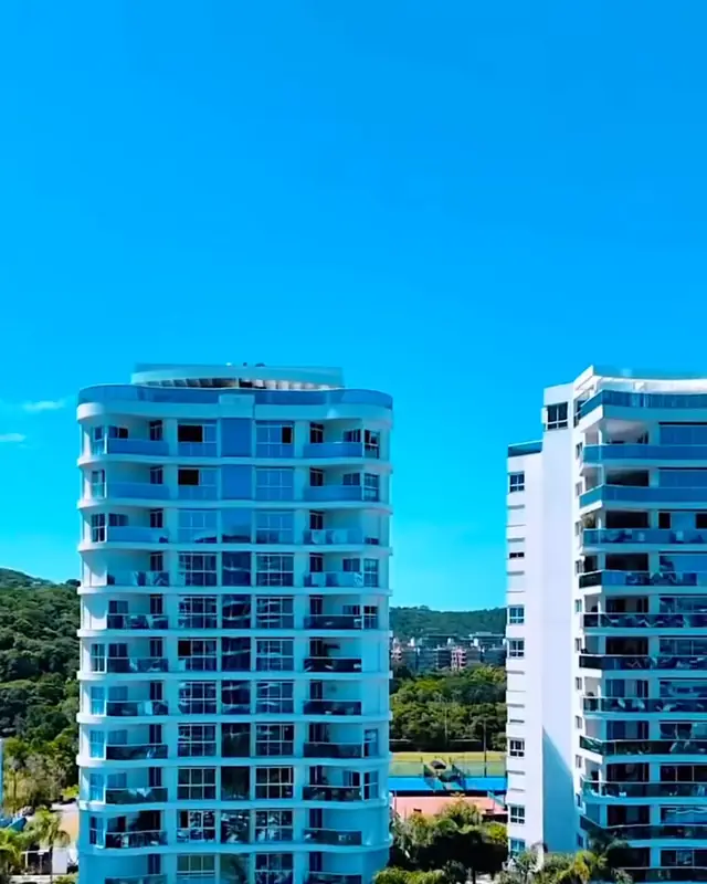 Torres residenciais da Praia Brava entre jardins, piscinas e morros com Mata Atlântica